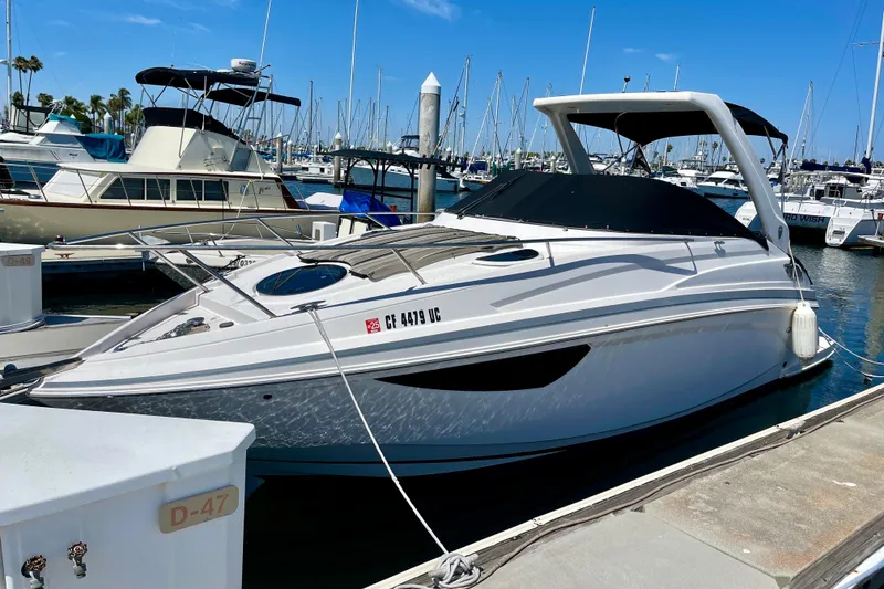 The Image of 2016 Regal 28 Express boat docked at marina under clear blue sky. - 0