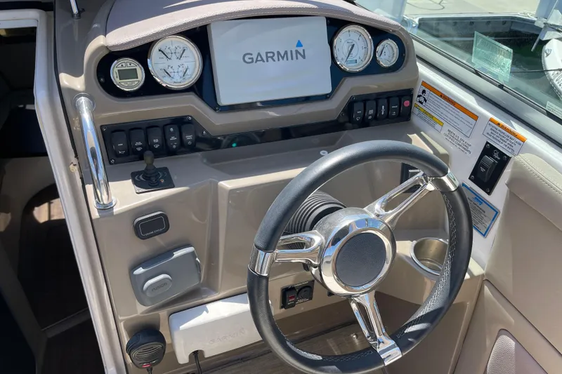 Slide: The Image of 2016 Regal 28 Express boat dashboard with Garmin display and steering wheel. - 10