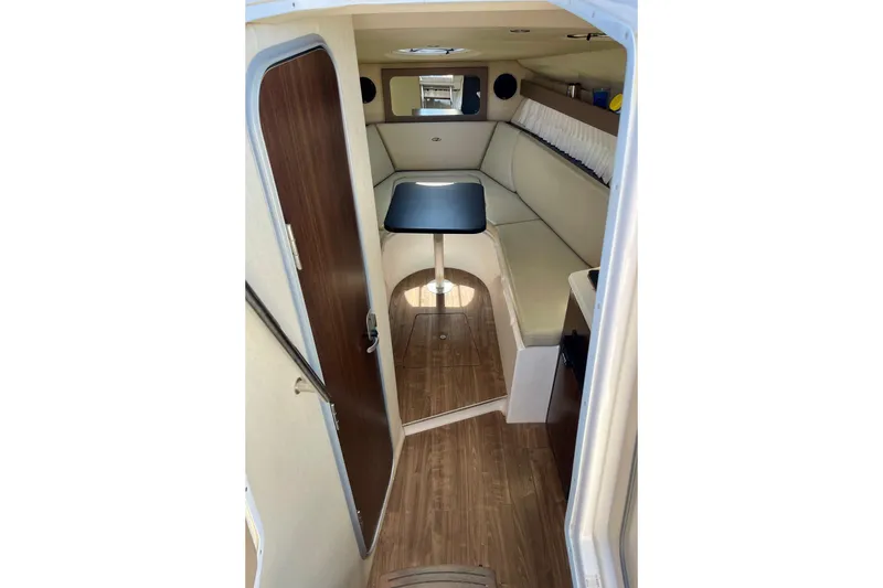 Slide: The Image of 2016 Regal 28 Express cabin interior with seating and table, featuring wood flooring. - 14