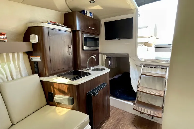 Slide: The Image of Interior of a 2016 Regal 28 Express boat with kitchenette and seating area. - 17