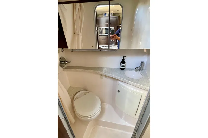 Slide: The Image of Compact bathroom in 2016 Regal 28 Express boat with toilet, sink, and mirror. - 21