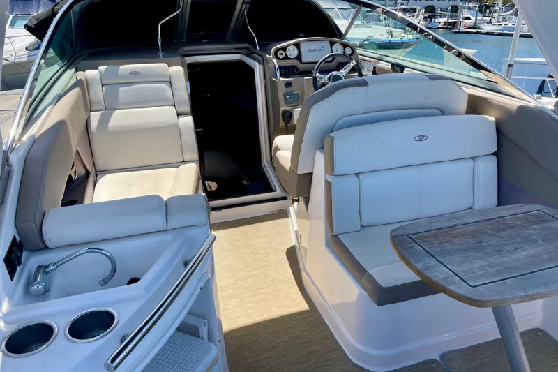 Slide: The Image of 2016 Regal 28 Express boat interior with seating, table, and helm at marina. - 4
