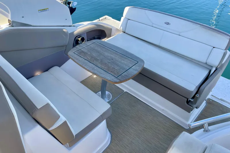Slide: The Image of 2016 Regal 28 Express boat interior with cushioned seating and wooden table. - 6