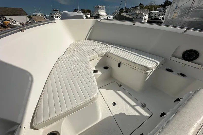 Slide: The Image of 2011 Sailfish 2660 CC boat interior with white cushioned seating and cup holders. - 10