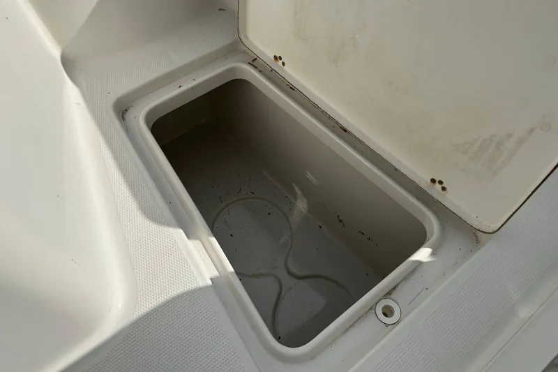 Slide: The Image of Open storage compartment on a 2011 Sailfish 2660 CC boat, showing interior details. - 11