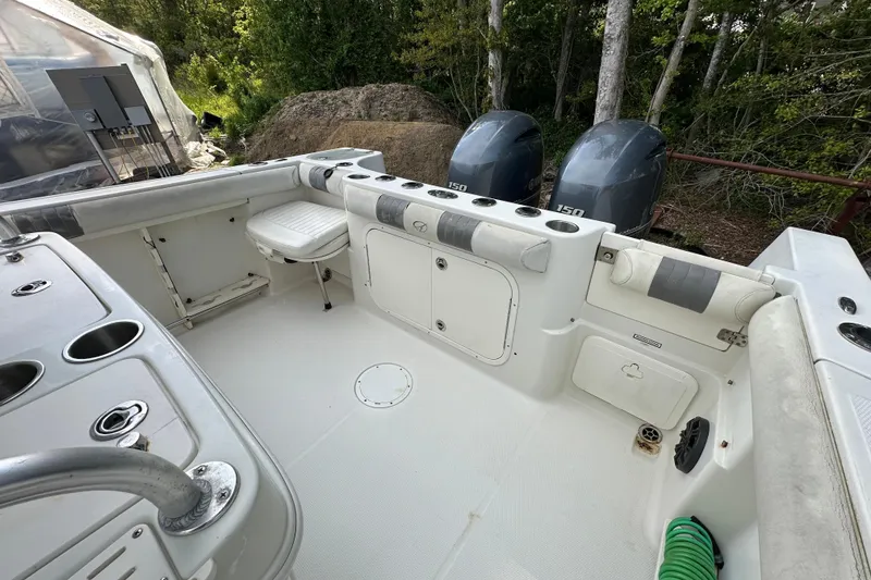 Slide: The Image of 2011 Sailfish 2660 CC boat interior with dual engines and seating, surrounded by greenery. - 13