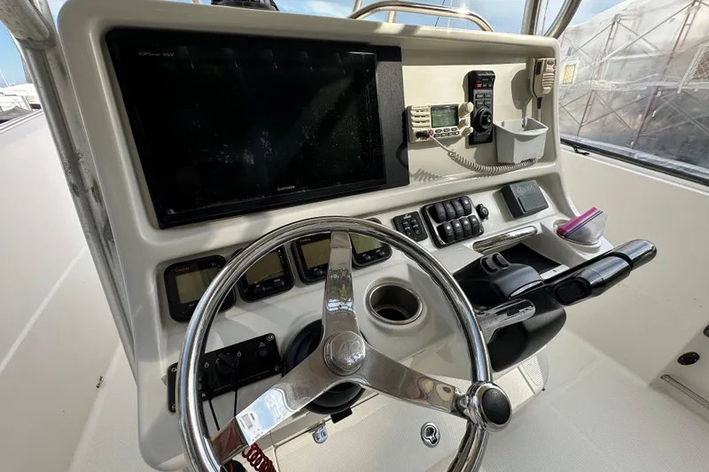 Slide: The Image of Control panel of a 2011 Sailfish 2660 CC boat with steering wheel and navigation equipment. - 15