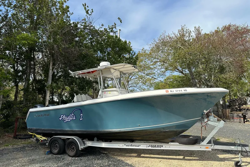 Slide: The Image of 2011 Sailfish 2660 CC boat on trailer, named "Phyllis 2," parked outdoors. - 5