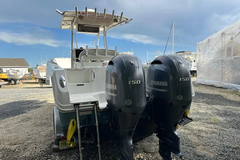 Slide: The Image of 2011 Sailfish 2660 CC boat with twin Yamaha 150 engines in a marina setting. - 9