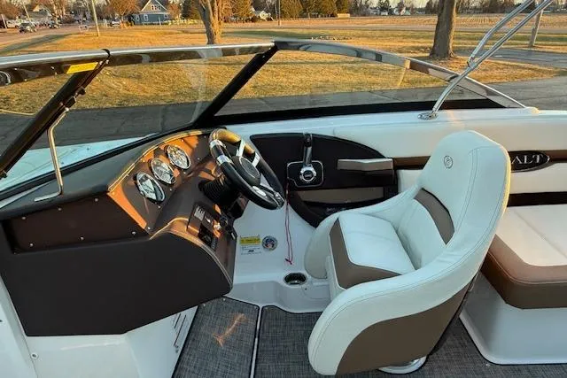 Slide: The Image of 2022 Cobalt CS22 boat interior with steering wheel, gauges, and cushioned seating. - 12