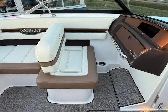 Slide: The Image of Interior of a 2022 Cobalt CS22 boat featuring stylish seating and dashboard design. - 16