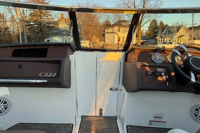 Slide: The Image of 2022 Cobalt CS22 boat interior with dashboard and steering wheel, parked in a residential area. - 18