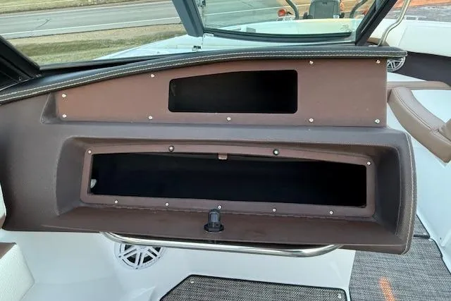 Slide: The Image of 2022 Cobalt CS22 boat dashboard with open storage compartments and speaker. - 20