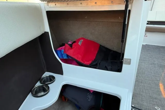 Slide: The Image of Storage compartment in a 2022 Cobalt CS22 boat with life jackets and cup holders. - 23