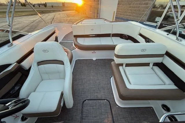 Slide: The Image of 2022 Cobalt CS22 boat interior with white and brown seating at sunset. - 27