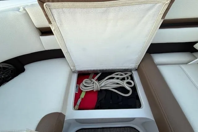 Slide: The Image of Open storage compartment in 2022 Cobalt CS22 boat with rope and life jacket. - 29