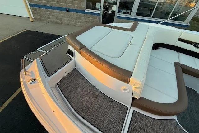 Slide: The Image of 2022 Cobalt CS22 boat with white and brown seating, docked near a building. - 34