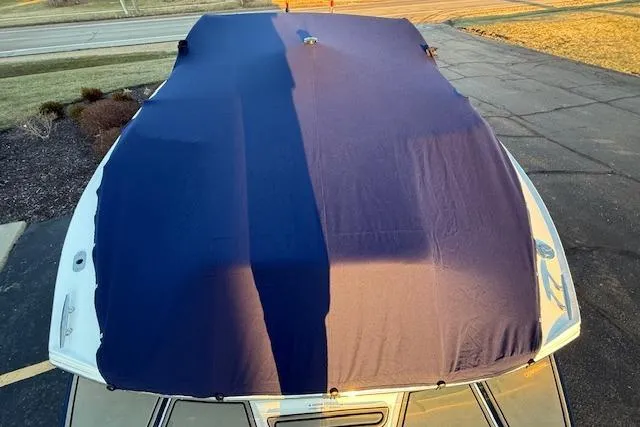 Slide: The Image of 2022 Cobalt CS22 boat covered with a protective tarp in a driveway. - 8