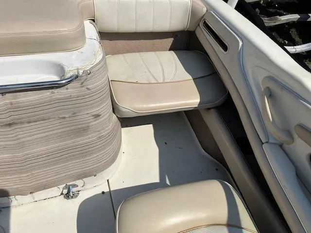 Slide: The Image of 1997 Sea Ray 190 Bow Rider interior seating area with beige upholstery. - 10