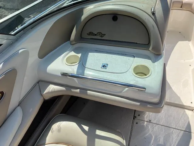 Slide: The Image of 1997 Sea Ray 190 Bow Rider interior with cup holders and storage compartment. - 6