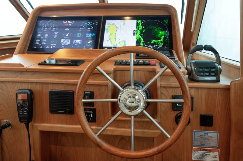 Slide: The Image of 2026 Sabre 45 Salon Express helm with advanced navigation displays and controls. - 13