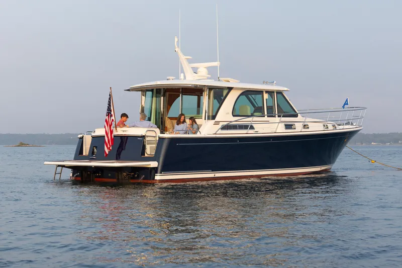 Slide: The Image of 2026 Sabre 45 Salon Express yacht on calm water with passengers onboard. - 3