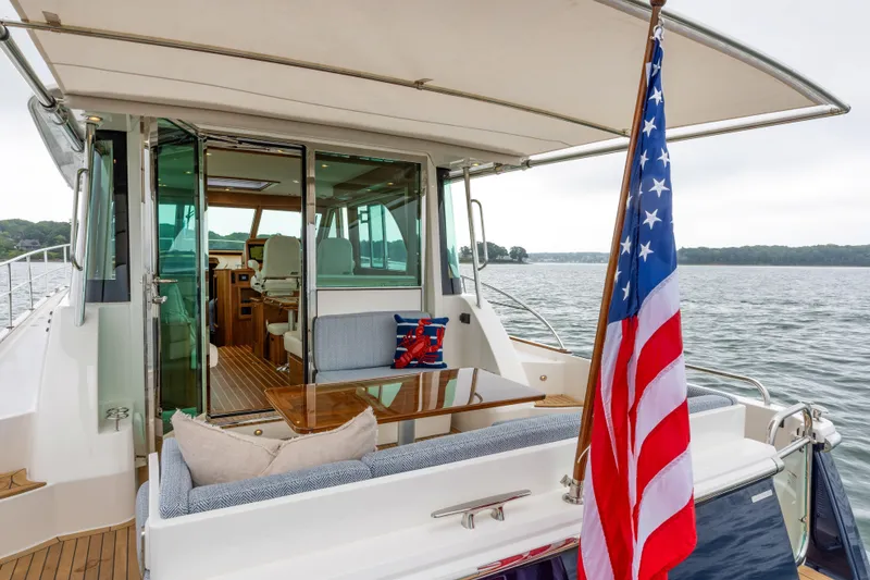 Slide: The Image of 2026 Sabre 45 Salon Express yacht with American flag, elegant interior, and scenic water view. - 6