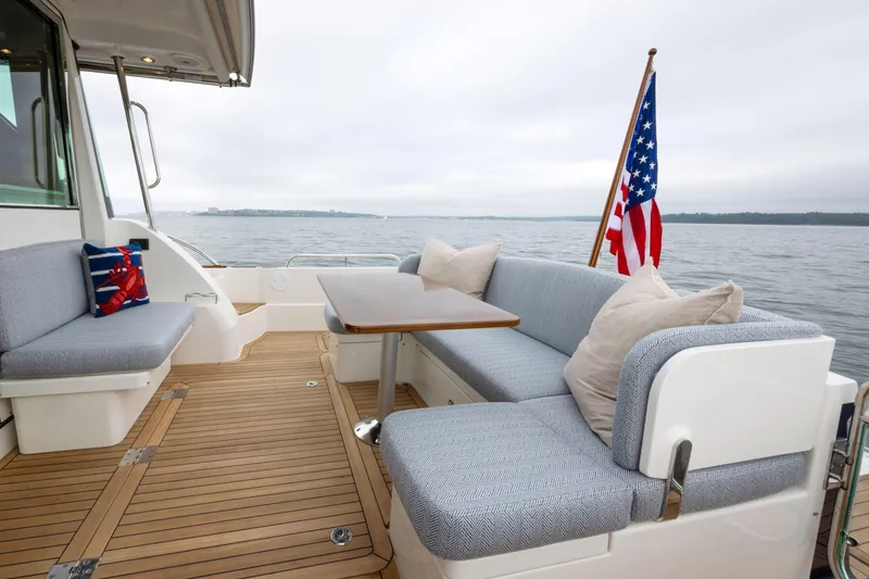Slide: The Image of Deck of 2026 Sabre 45 Salon Express yacht with seating and American flag. - 7