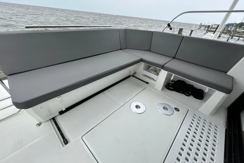 Slide: The Image of 2024 Beneteau Antares 11 boat deck with gray seating, overlooking the water. - 2