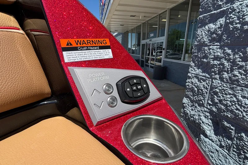Slide: The Image of Control panel and cup holder on 2026 Tigé Ultré 25ZX boat with warning label. - 10