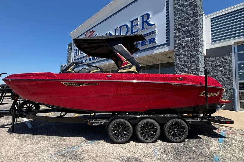 Slide: The Image of 2026 Tigé Ultré 25ZX boat in vibrant red on a trailer outside a dealership. - 11