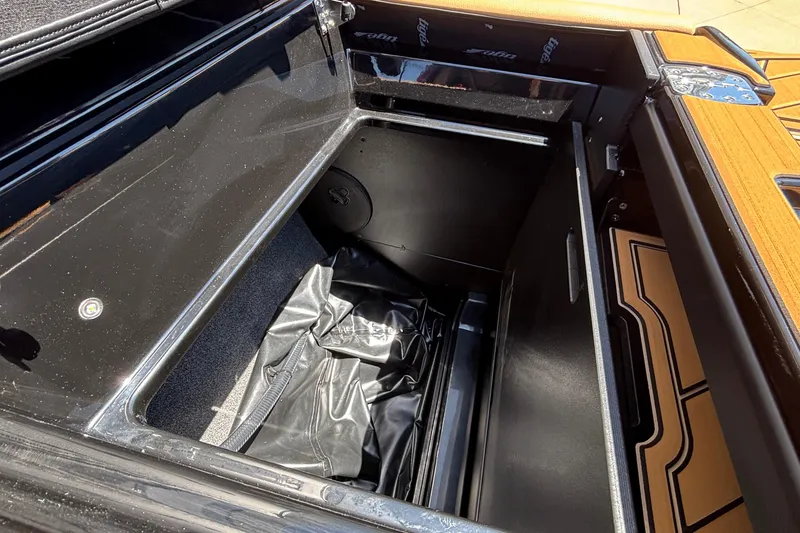Slide: The Image of Storage compartment of 2026 Tigé Ultré 25ZX boat, featuring sleek black interior design. - 32