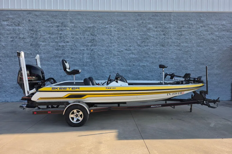 The Image of 2014 Skeeter TZX195 bass boat on trailer, parked outdoors against a gray wall. - 8