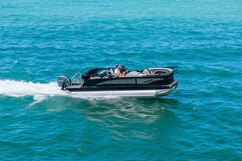 Slide: The Image of 2025 Barletta Corsa 23UC pontoon boat cruising on clear blue water. - 3