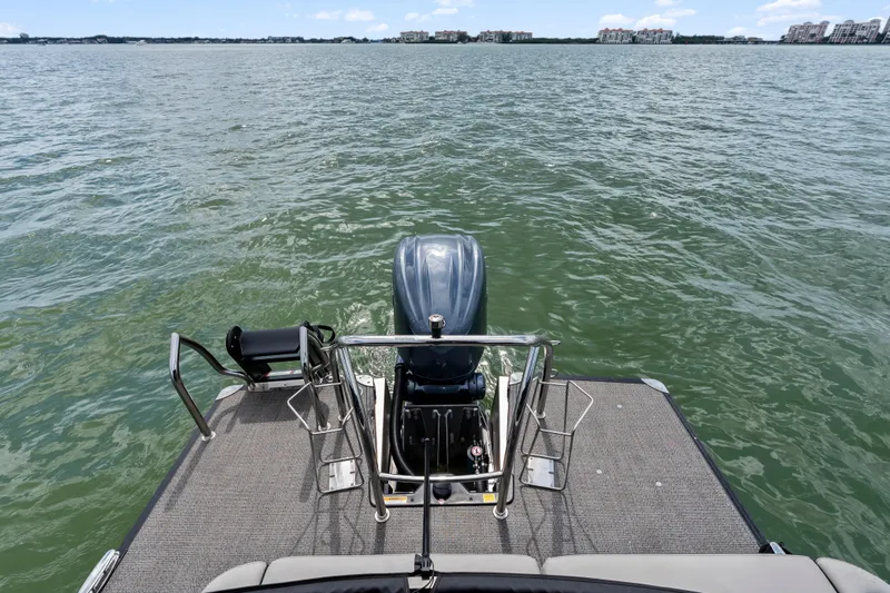 Slide: The Image of 2025 Barletta Corsa 23UC pontoon boat with outboard motor on a calm lake. - 4