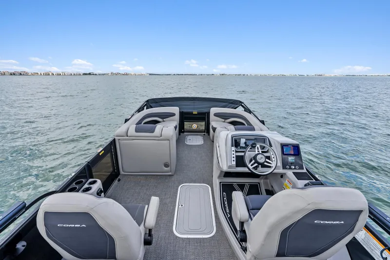 Slide: The Image of 2025 Barletta Corsa 23UC pontoon boat interior with modern helm and seating on open water. - 9