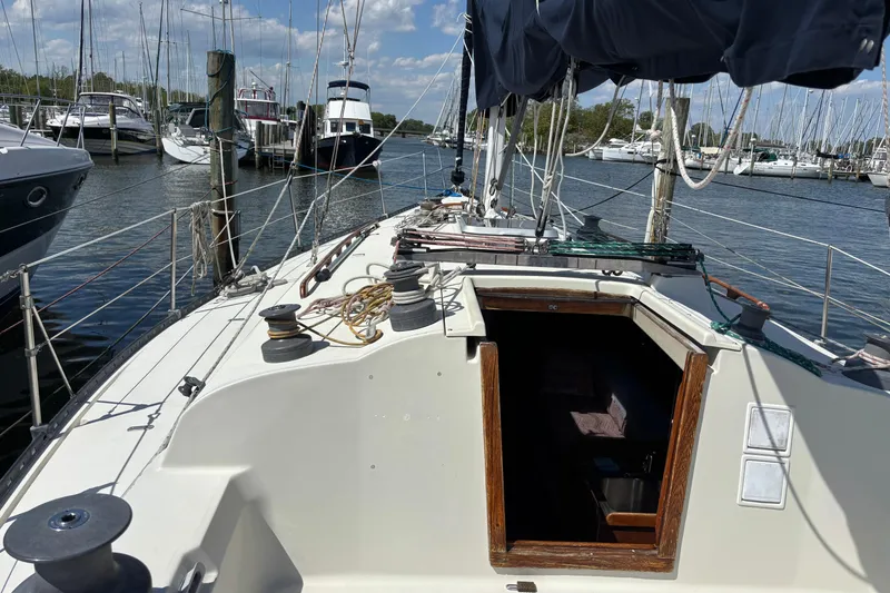 Slide: The Image of 1980 C&C 40-2 sailboat docked at marina, clear sky, calm water. - 11