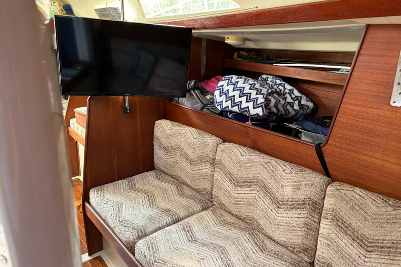 Slide: The Image of Interior of a 1980 C&C 40-2 sailboat with cozy seating and a mounted TV. - 13