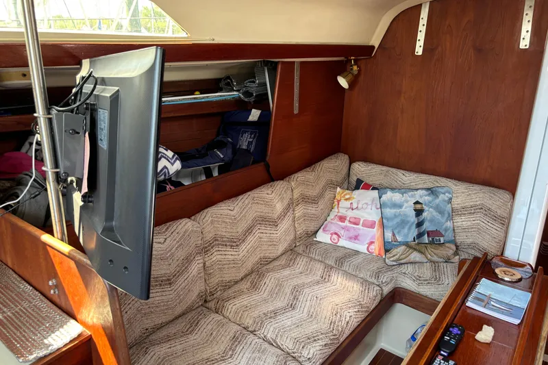 Slide: The Image of Cozy interior of a 1980 C&C 40-2 sailboat with cushions and a mounted TV. - 14