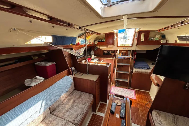 Slide: The Image of Interior of a 1980 C&C 40-2 sailboat, featuring cozy seating and wooden finishes. - 17