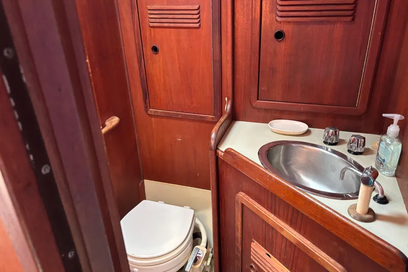 Slide: The Image of 1980 C&C 40-2 yacht bathroom with wooden cabinetry, sink, and toilet. - 18