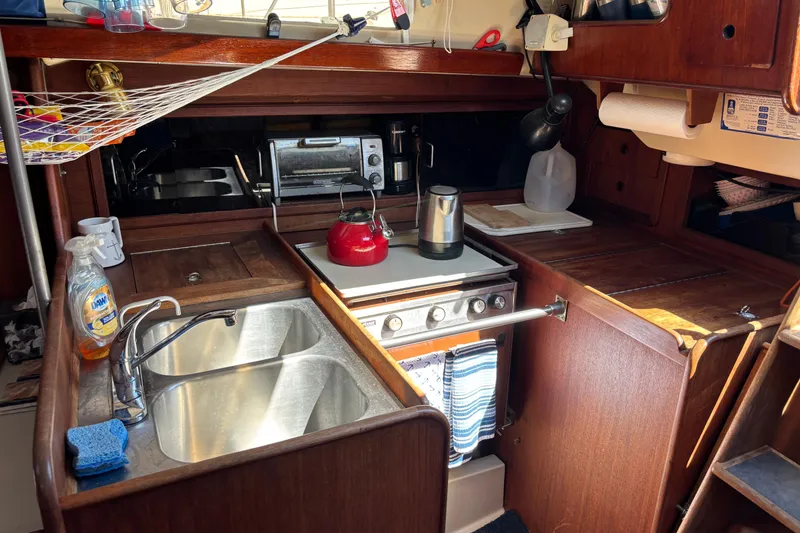 Slide: The Image of Compact galley kitchen in a 1980 C&C 40-2 sailboat with sink, stove, and kettle. - 24