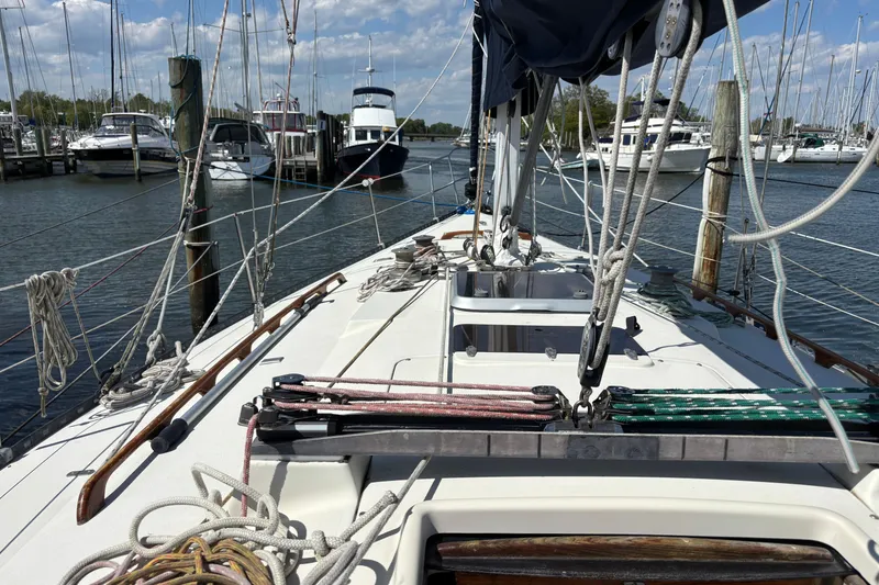 Slide: The Image of 1980 C&C 40-2 sailboat docked in a marina, surrounded by other boats. - 5