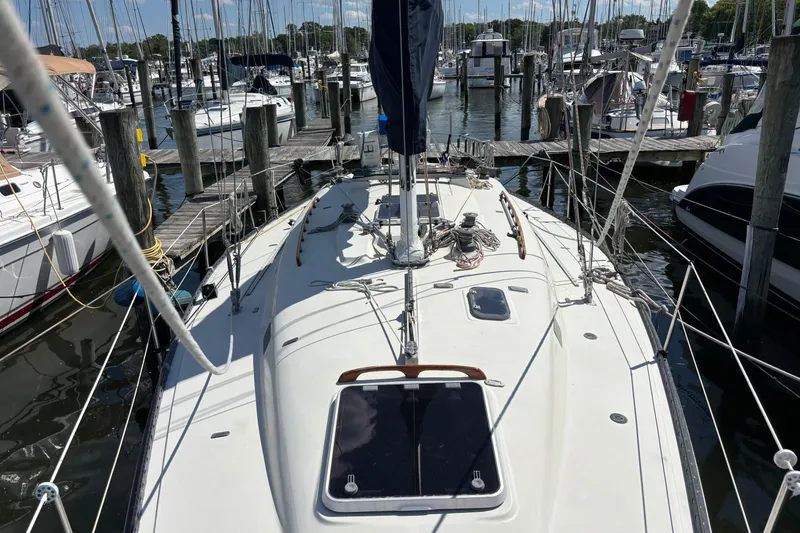Slide: The Image of 1980 C&C 40-2 sailboat docked at a marina, surrounded by other boats. - 7