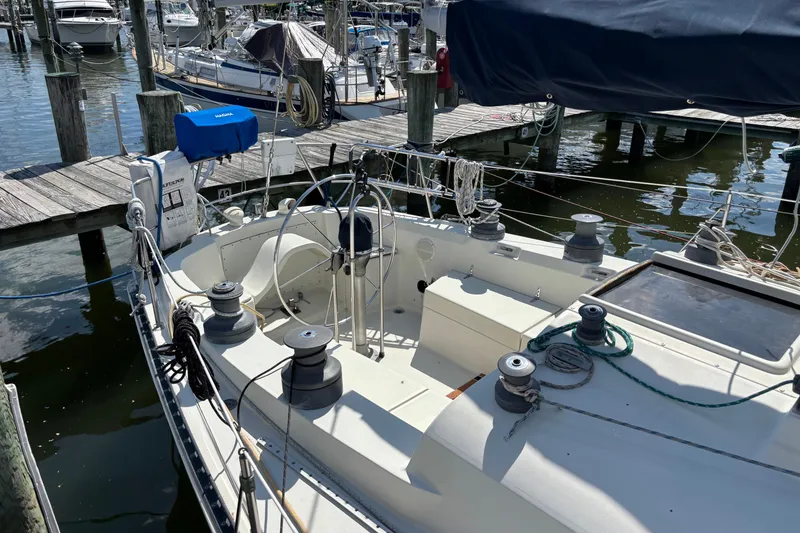 Slide: The Image of 1980 C&C 40-2 sailboat docked at marina, featuring spacious cockpit and rigging. - 9