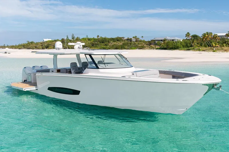 Slide: The Image of Manufacturer Provided Image: 2026 Regal 50 SAV yacht anchored in clear turquoise water near a sandy beach. - 2