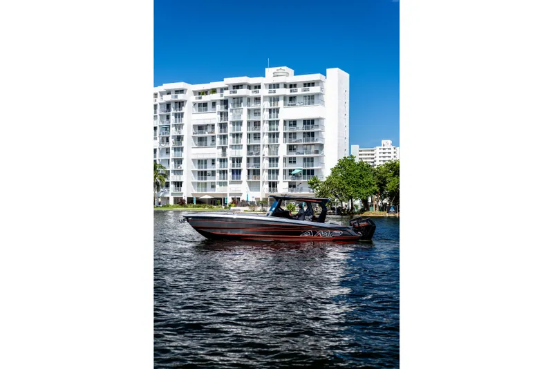 The Image of AMP 333 boat cruising on water near modern white building, 2026 model. - 1