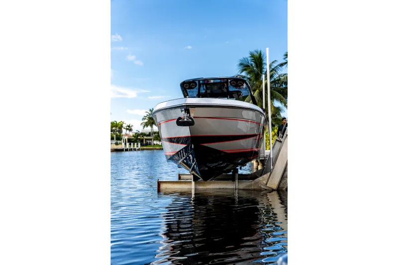 Slide: The Image of AMP 333 boat from 2026 on a lift by the water, with palm trees. - 14
