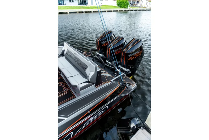 Slide: The Image of 2026 AMP 333 boat with triple 400 horsepower engines docked on a calm waterway. - 7
