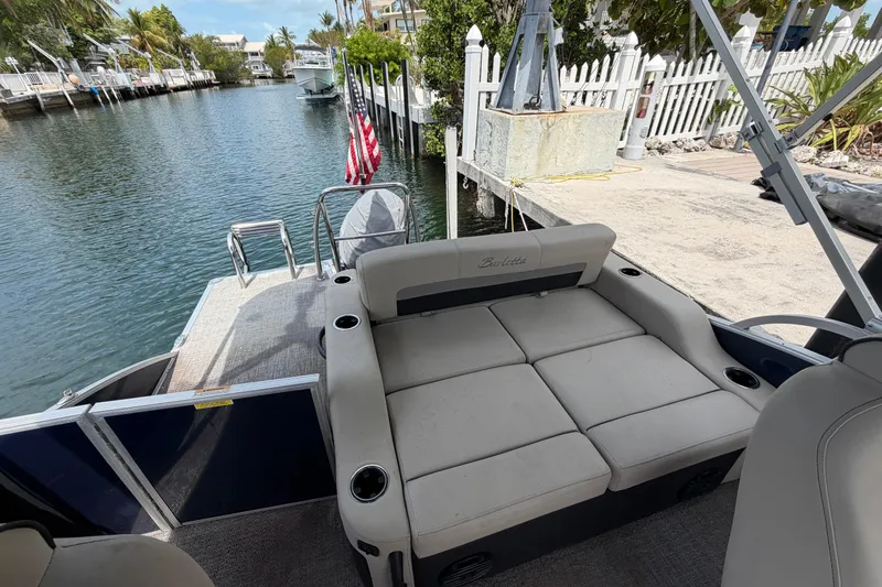 Slide: The Image of 2021 Barletta C20UC pontoon boat with seating, docked by a canal. - 8